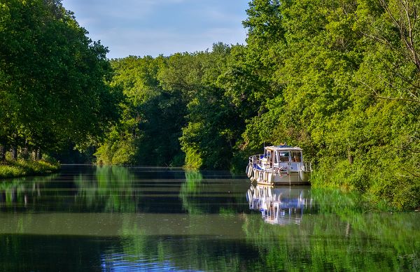 Boat in lush area around Canal du Midi in France.