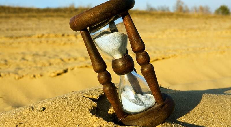 Hourglass on a beach in late afternoon