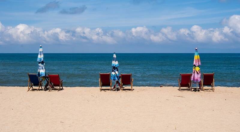 Beach with chairs and blue sea behind