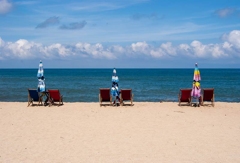 Beach with chairs and blue sea behind