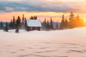 Winter landscape with cottage, deep snow and sunset.