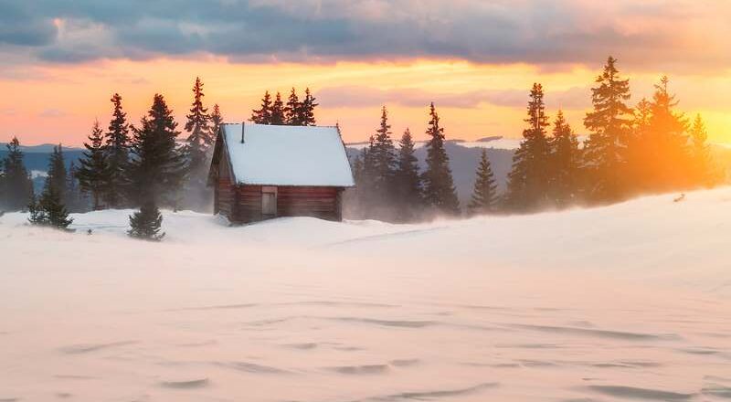 Winter landscape with cottage, deep snow and sunset.